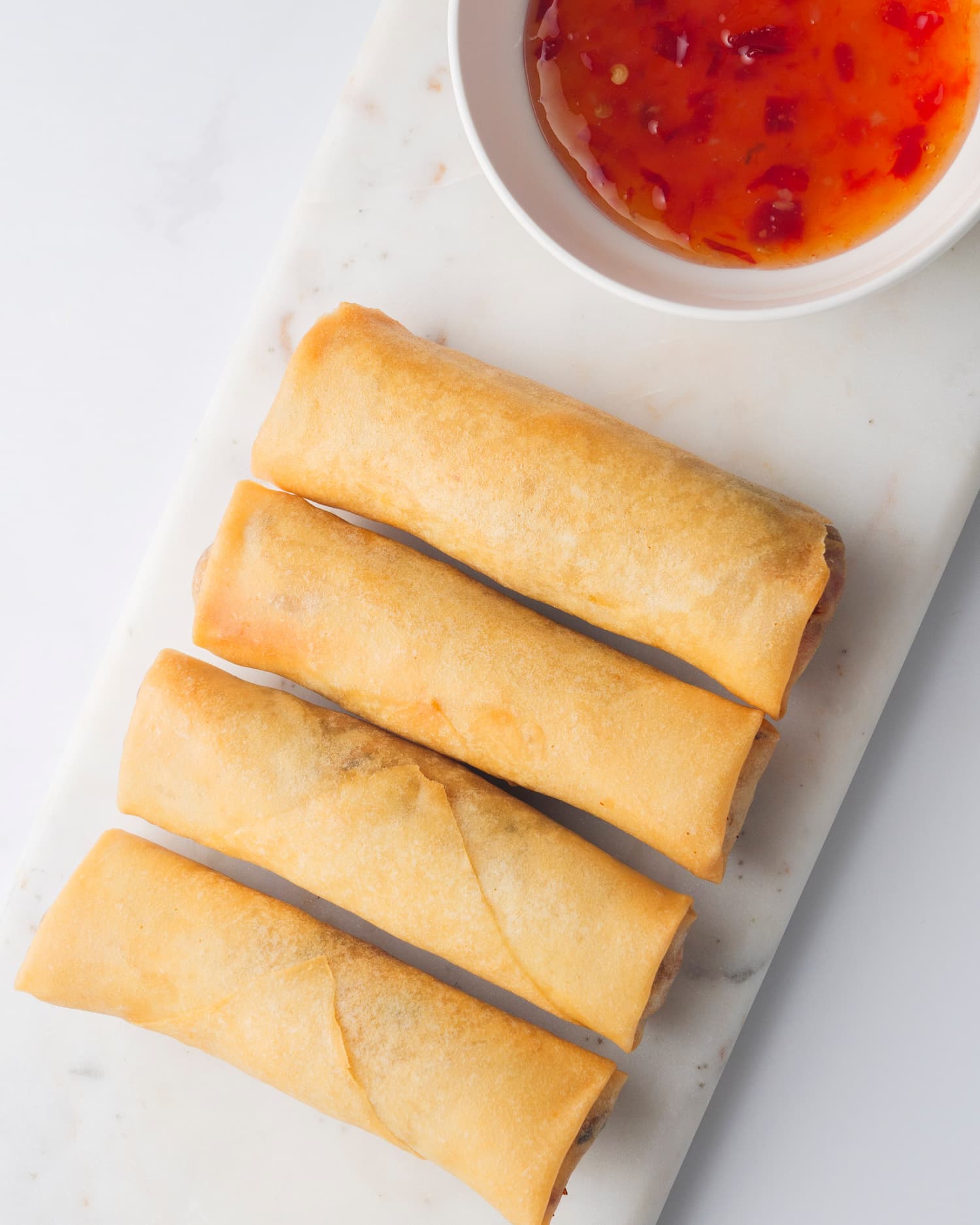 4 piece of Spring Rolls served with a bowl of sauce