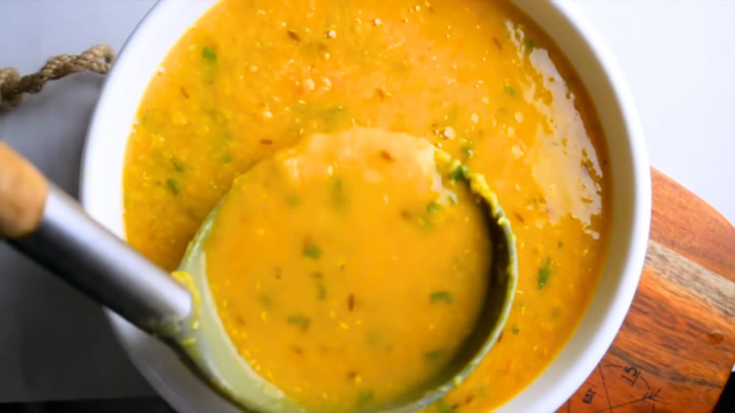 masoor dal or red lentil curry in a serving bowl with a ladle