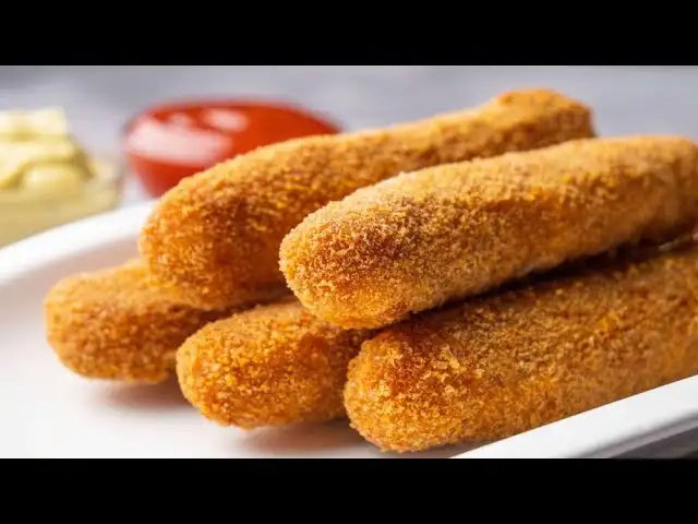 chicken cheese fingers on a serving plate with dipping sauce