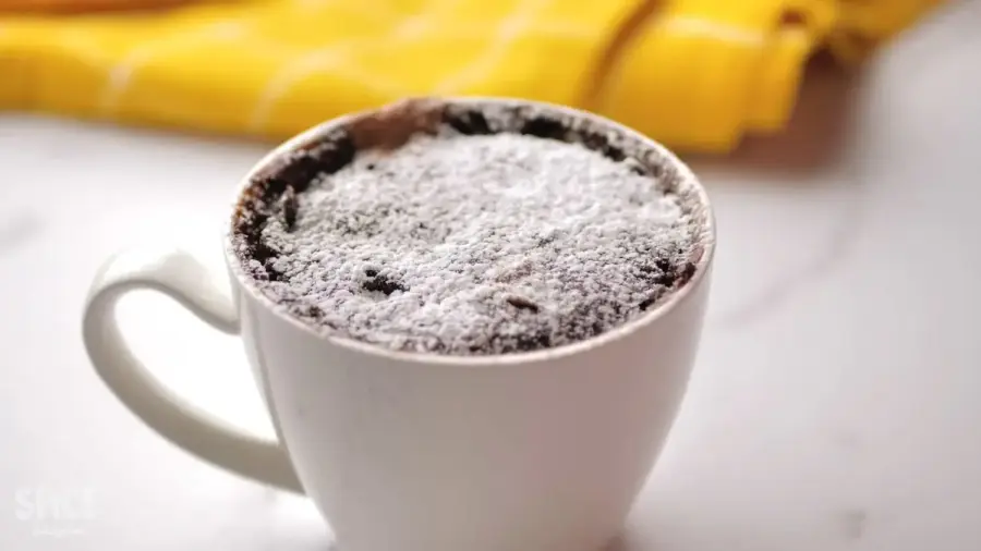 1 Minute Perfect Chocolate Mug Cake topping with chocolate powdered sugar