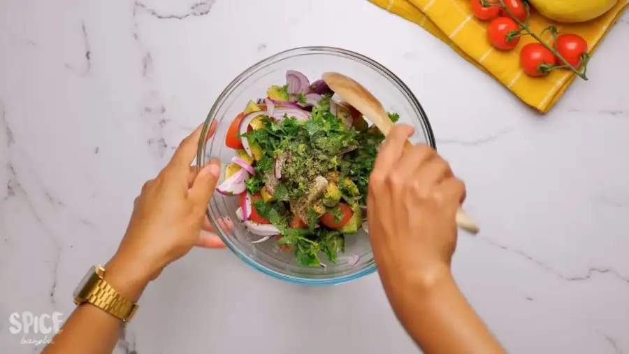 Cucumber Tomato And Avocado Salad in a large mixing bowl with a spatula