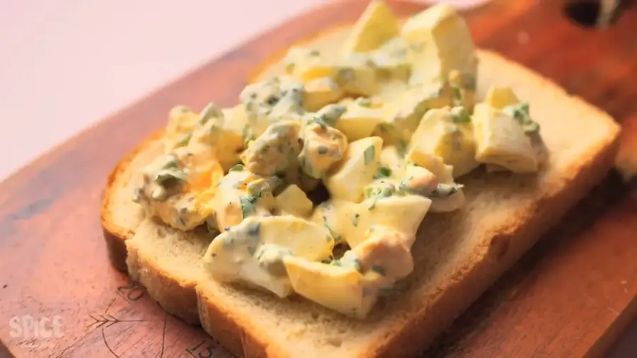 Egg salad sandwich recipe: egg salad spreading on bread