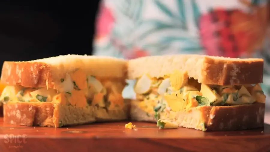 Egg salad sandwich on a cutting board sliced in Half