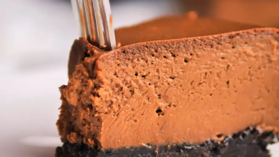 The Ultimate Chocolate Cheesecake serving on a plate with a fork