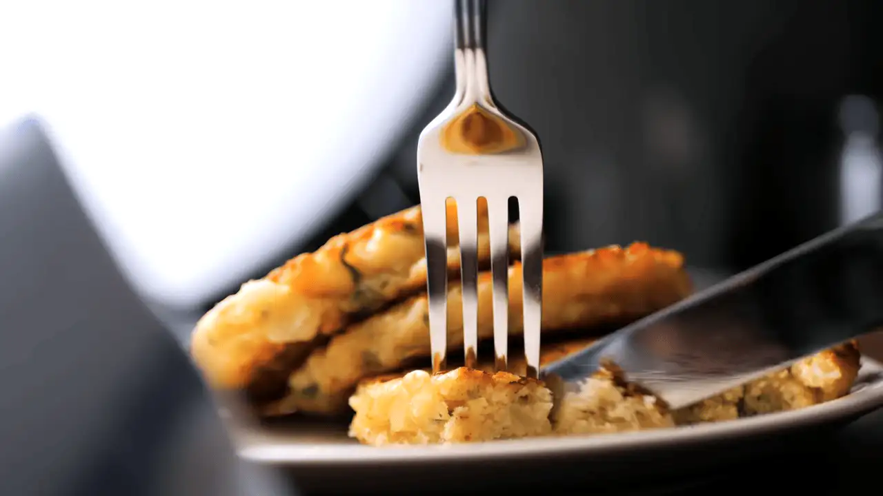 Piece of savory pancakes cut with a bread knife and fork