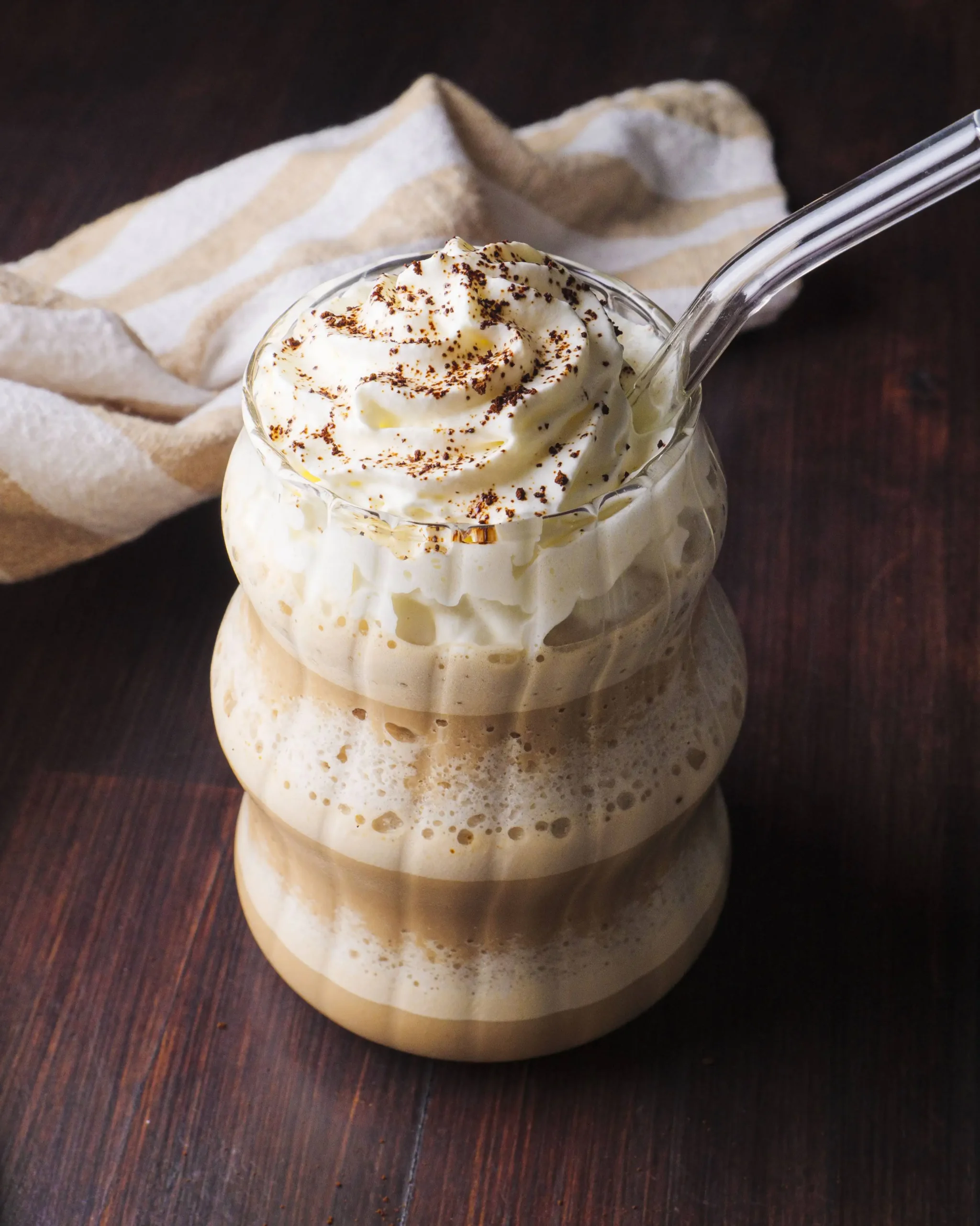 Coffee Frappuccino in a glass with a straw