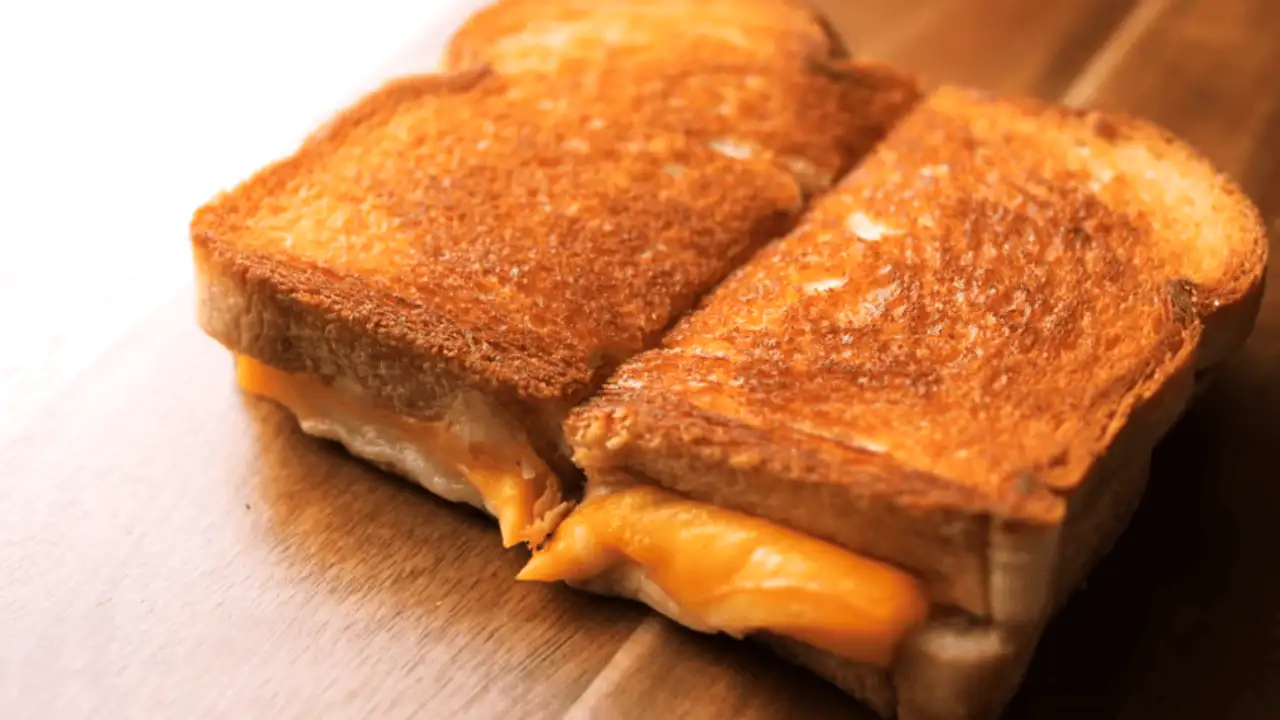 Grilled Cheese Sandwich Recipe sliced in half placing on a board