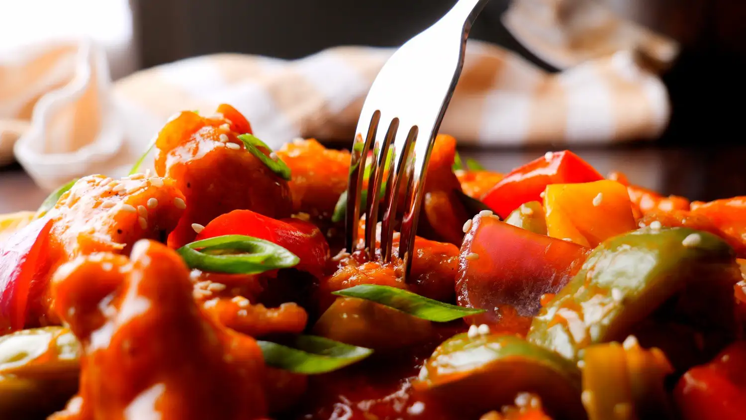 Sweet and Sour Chicken Recipe on a serving plate with a fork