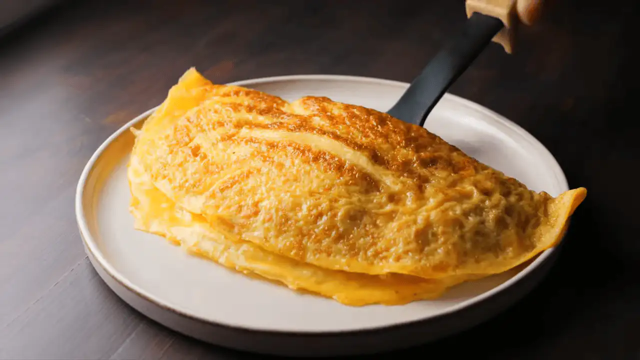 Cheese Omelette pieces on a serving plate with a spatula