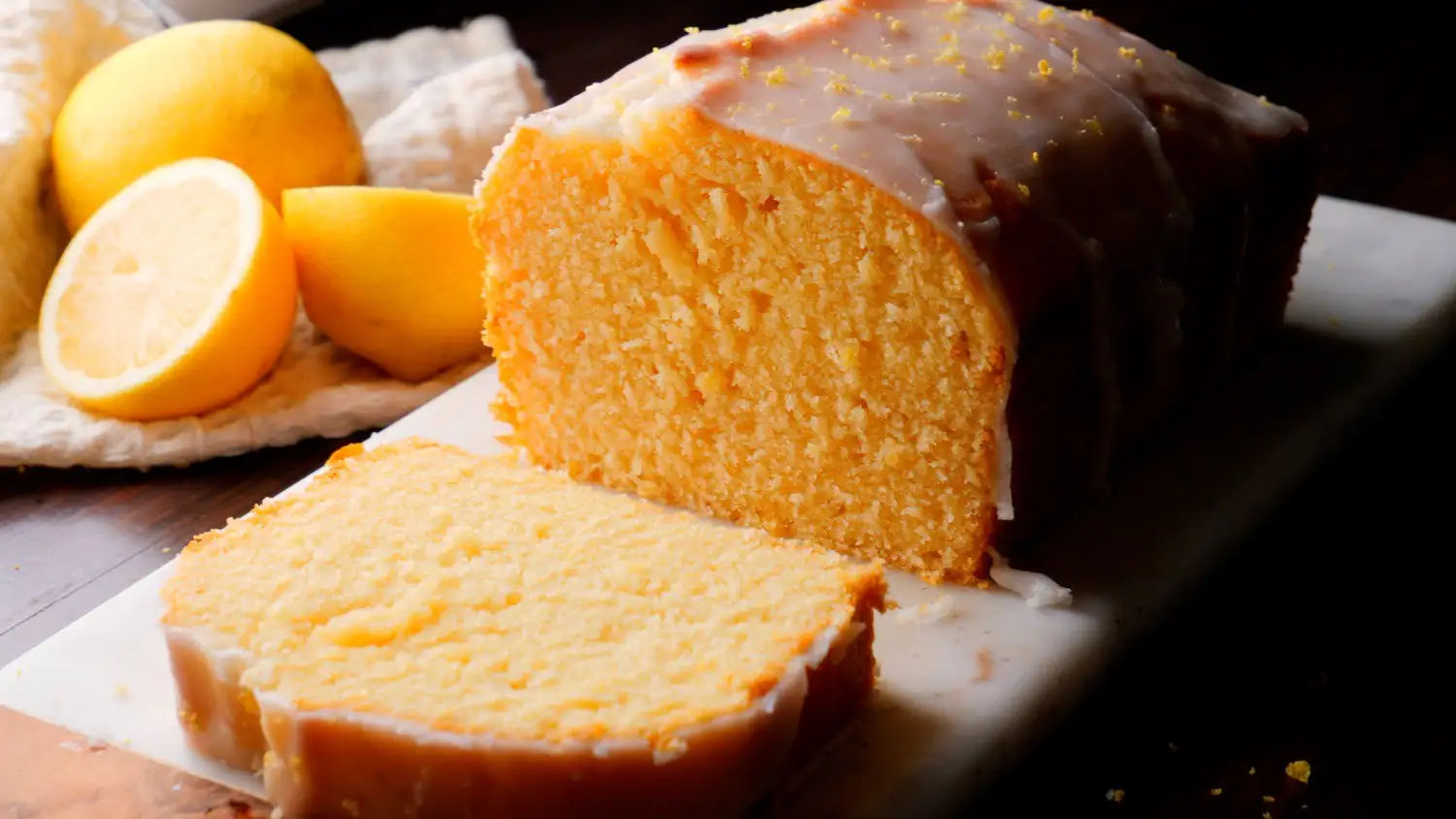 Lemon Loaf Cake with a piece falling on the surface