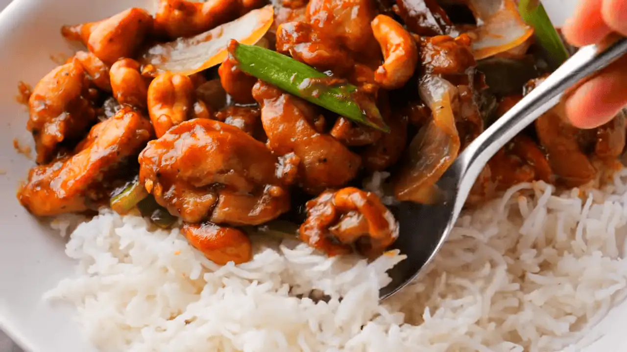 Thai Cashew Chicken with rice on a serving plate with a spoon