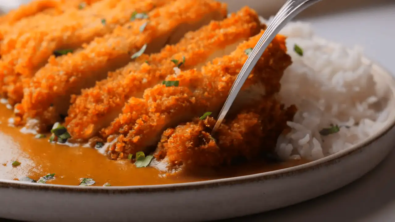 Japanese Chicken Katsu Curry serving with rice on a serving plate with a fork