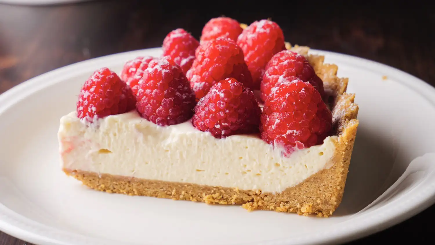 One Piece Of No-Bake Fresh Raspberry Tart On A Serving Plate