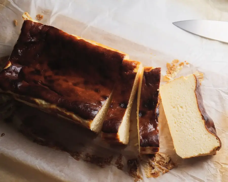 Loaf Pan Basque Cheesecake on a serving board with slices