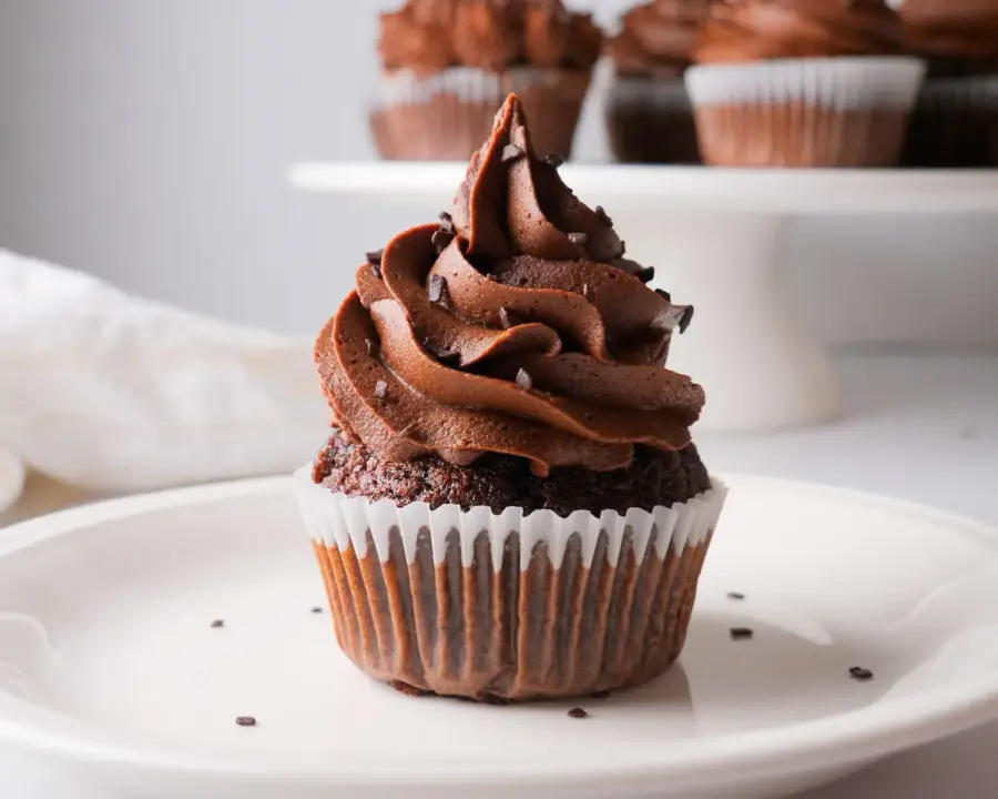 Chocolate Buttercream Frosting on a cupcake on a serving plate 