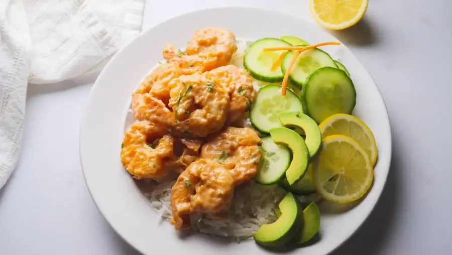 Boom Boom Shrimp Recipe on a serving plate served with rice, avocado salad and lemon